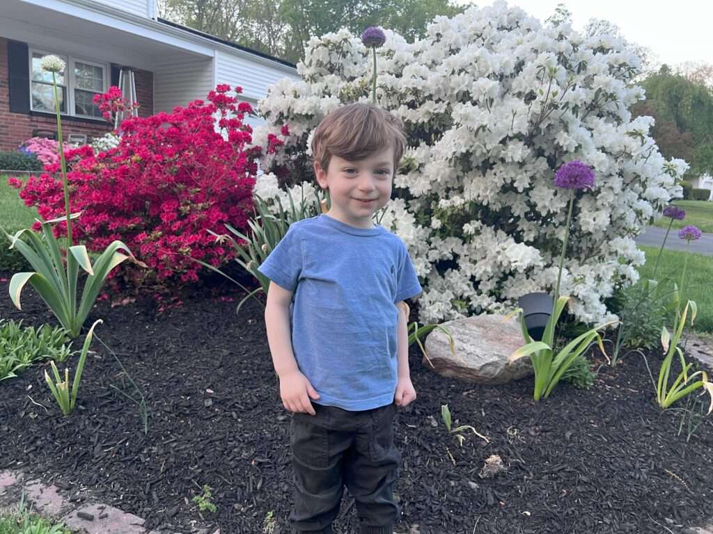 boy in front of bushes